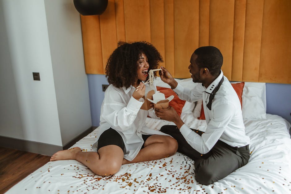 A couple enjoying a meal in a bedroom setting, capturing a bonding moment indoors.