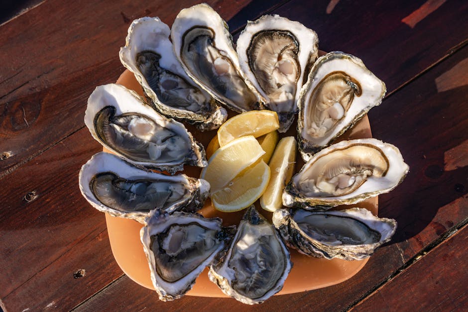 Close-up of fresh oysters served with lemon slices on a wooden table.