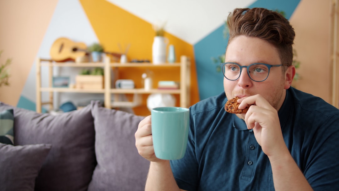 Man eating a cookie and holding a mug