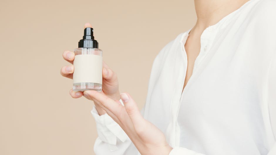 Close-up of a person holding a minimalist design perfume bottle for product mockup.