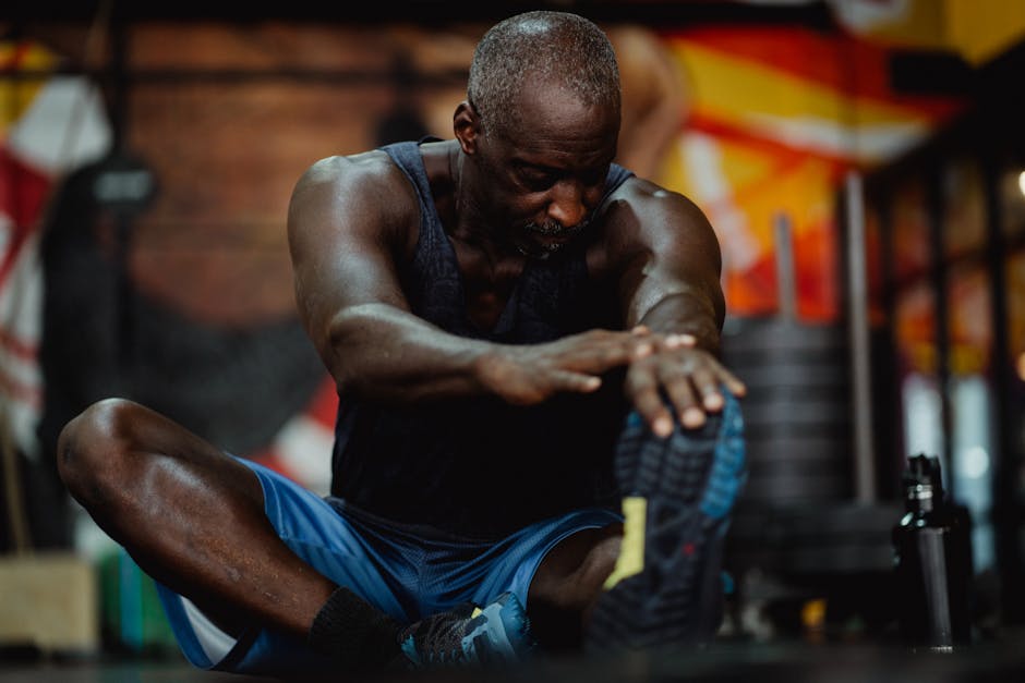 Focused middle-aged black man stretching indoors, promoting fitness well-being.