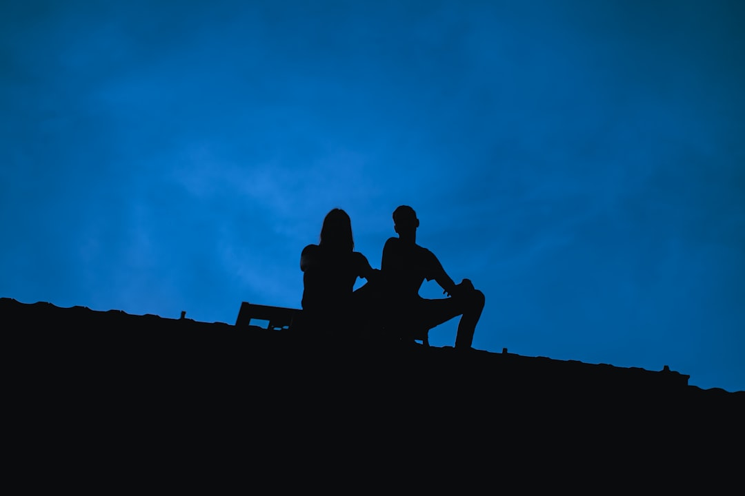 a couple of people sitting on top of a hill