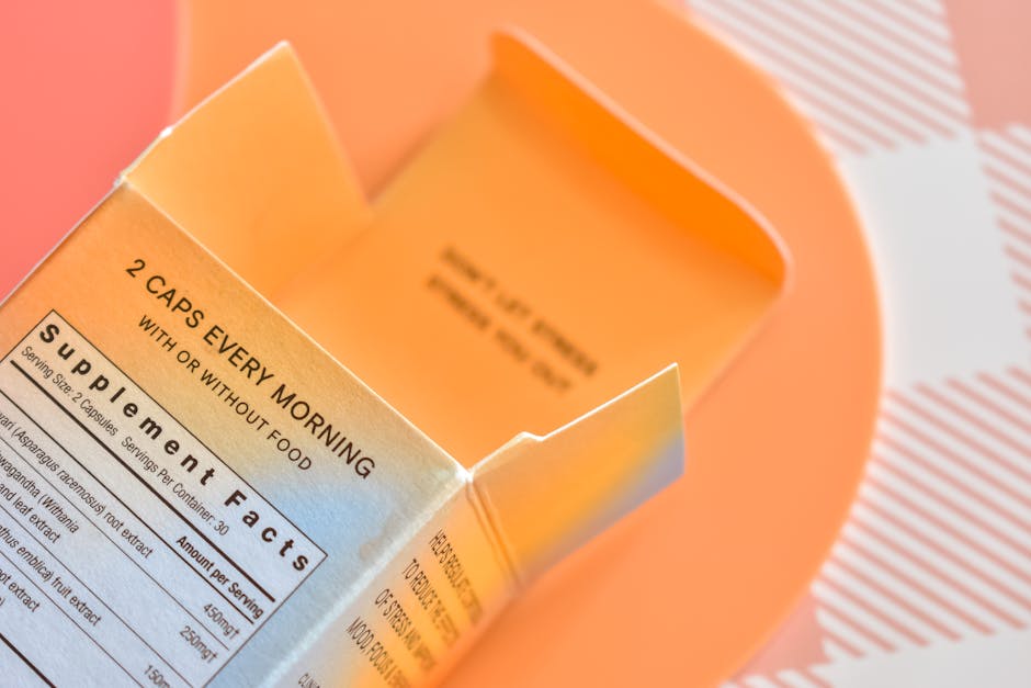 High angle view of an open supplement box on a peach-themed surface